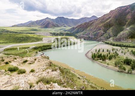 Rive rocheuse abrupte d'une rivière de montagne près de la confluence des rivières Chuya et Katun, la confluence de deux rivières avec l'eau claire et boueuse Banque D'Images