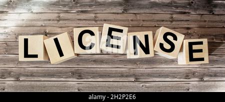 MOT DE LICENCE composé de blocs de construction sur fond en bois Banque D'Images