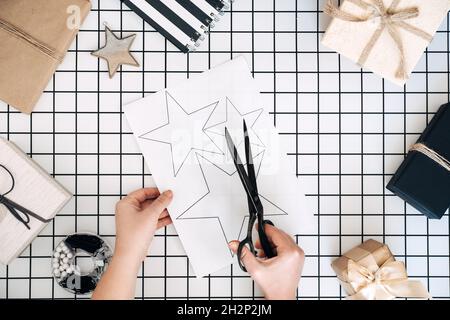Idées créatives d'emballage de cadeaux.Cadeaux personnalisés.Plat moderne noir et blanc avec processus d'emballage cadeau. Ciseaux, boîtes d'artisanat enveloppées et Banque D'Images