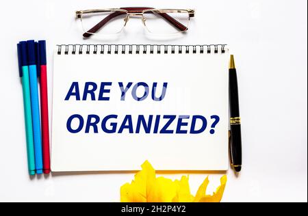 Le Bloc-notes avec du texte est organisé.Arrière-plan blanc avec papeterie. Banque D'Images