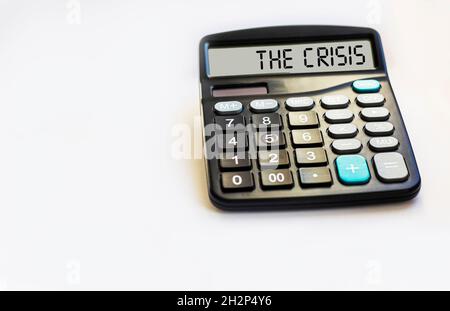 Calculatrice avec l'inscription LA CRISE se trouve sur un fond blanc dans le bureau.Concept d'entreprise. Banque D'Images