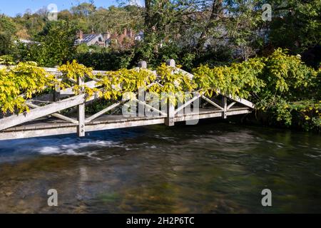 Une passerelle à travers le ruisseau de craie transparent de la rivière Itchen à Winchester, Hampshire, Royaume-Uni Banque D'Images