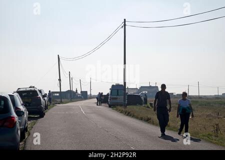 Personnes marchant le long de Dungeness Road lors d'une journée ensoleillée à l'automne Dungeness Kent England UK KATHY DEWITT Banque D'Images