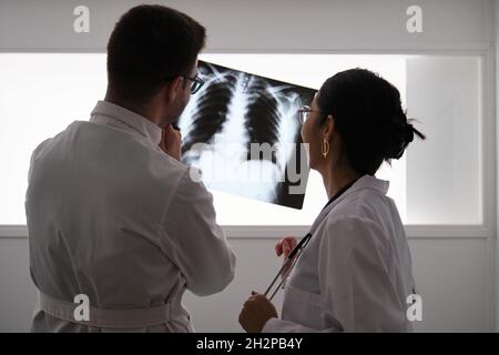 Équipe médicale professionnelle examinant la radiographie d'un patient. Banque D'Images