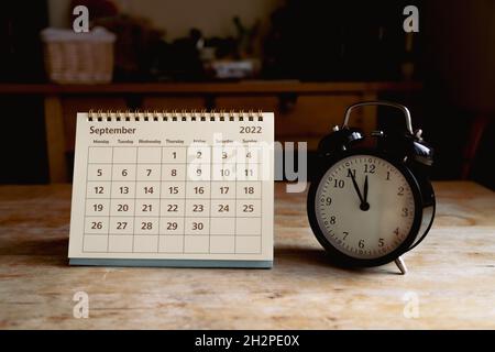 Calendrier de septembre 2022 et horloge vintage noire sur table en bois Banque D'Images