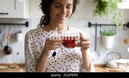 Bonne femme prenant une pause-thé, tenant une tasse en verre Banque D'Images