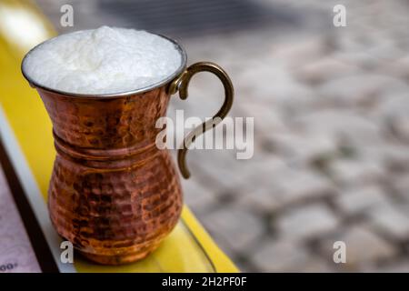 Ayran, boisson traditionnelle turque au yaourt (babeurre) avec mousse servie dans une tasse de métal traditionnelle en dinde.Mise au point sélective en gros plan Banque D'Images