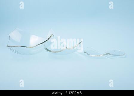 Morceaux de verre cassés sur fond bleu pastel. Banque D'Images