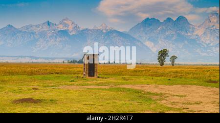 outhouse sur le quartier historique de Mormon Row avec la chaîne de montagnes Teton en arrière-plan Banque D'Images