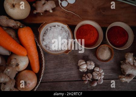 Ingrédients frais et légumes placés dans le tableau pour la fabrication de Kimchi qui contient des ingrédients tels que le gingembre, l'ail, le sel, l'oignon, le sucre, le gochugar Banque D'Images