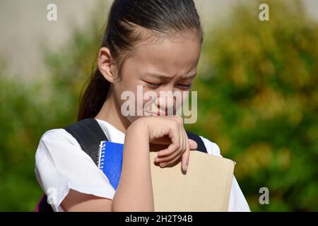 Pleurer belle fille minoritaire étudiant avec des livres Banque D'Images