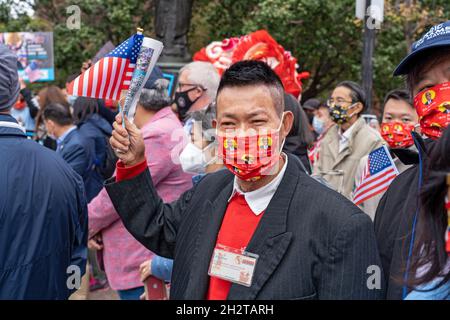 New York, États-Unis.23 octobre 2021.Un partisan du candidat démocrate à la mairie et le président du quartier de Brooklyn, Eric Adams, fait monter le drapeau américain lors du rassemblement de vote le premier jour du vote par anticipation dans le quartier chinois de New York.Crédit : SOPA Images Limited/Alamy Live News Banque D'Images