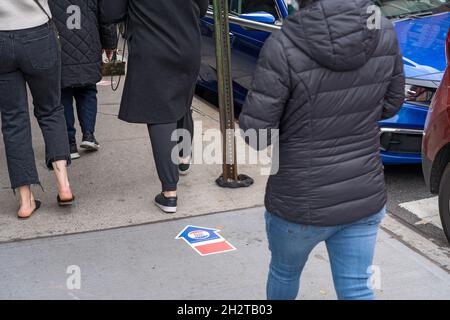 New York, États-Unis.23 octobre 2021.Les gens marchent près d'un panneau de trottoir pour diriger les gens vers le site de vote au 155, rue Sullivan, à SoHo, le premier jour du vote par anticipation pour l'élection de la mairie de New York à New York.Crédit : SOPA Images Limited/Alamy Live News Banque D'Images