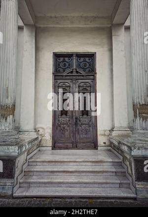 Porte d'époque et façade ouvragée d'un ancien bâtiment historique.Éléments d'architecture d'extérieur, colonnes blanches sur les marches de porte.Bois rustique ga Banque D'Images