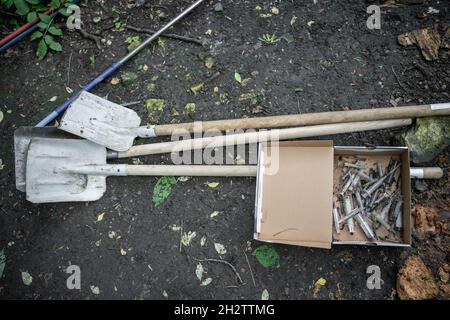 volontaire nettoyant le parc à partir de la seringue utilisée par les accros de drogue Banque D'Images