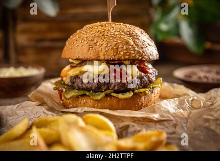 Savoureux hamburger maison grillé avec du bœuf, du fromage et du concombre Banque D'Images