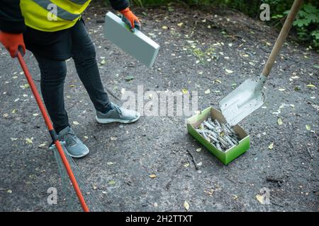 volontaire nettoyant le parc à partir de la seringue utilisée par les accros de drogue Banque D'Images