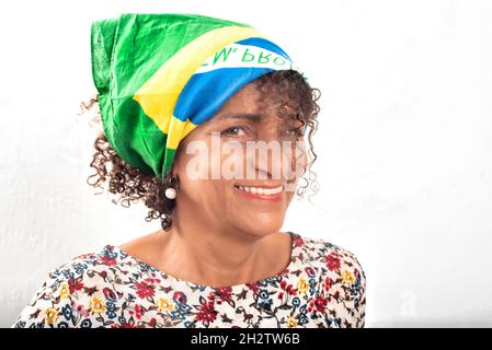 Portrait d'une femme brésilienne mûre et souriante portant un bandana avec le drapeau national Banque D'Images