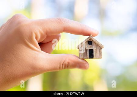 Gros plan d'une figurine de maison à la main.Concept d'assurance de biens résidentiels. Banque D'Images