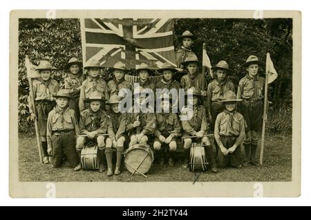 Carte postale originale du début des années 1900 du 1er groupe de troupes scoutes de la Cour des évêques de Freshfield (fondé en 1915), avec drapeau de l'Union Jack et de Freshfield, la Cour des évêques et le motif scout brodés.Les garçons à l'avant tiennent leur batterie, portent des chapeaux et certains tiennent des drapeaux.Evêque's court School, Freshfield, Formby, Liverpool, Lancashire,Royaume-Uni vers 1918, 1919 ou début des années 1920 Banque D'Images