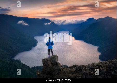 Randonneur surplombant le coucher du soleil depuis le point de vue de Mount Storm King, parc national olympique, Washington Banque D'Images