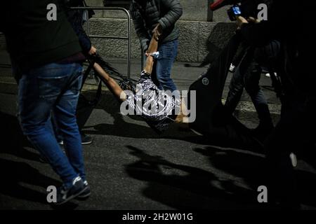 Milan, Italie - 23 octobre 2021 : un homme est détenu par la police alors que des gens se rassemblent pour protester contre le Green Pass, obligatoire pour tous les travailleurs publics et privés Banque D'Images