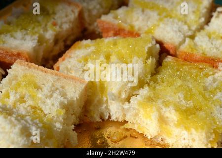 Morceaux de pain frais italien graissés à l'huile d'olive placés sur le plateau doré sous le soleil éclatant. Vue rapprochée. Banque D'Images