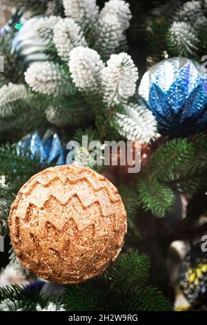 Gros plan d'un sapin de Noël décoré avec soin, orné de boules bleu vif et beige.Image verticale Banque D'Images