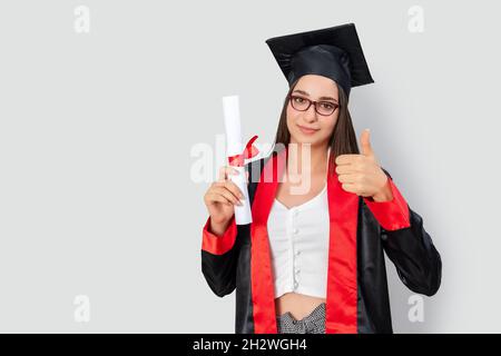 Une jolie étudiante aux cheveux rouges, tenant ses livres d'étude et célébrant sa graduation avec succès. Photo de haute qualité Banque D'Images