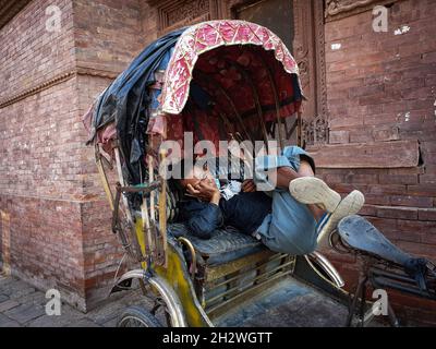 Katmandou, Bagmati, Népal.24 octobre 2021.Un extracteur de pousse-pousse nap sur son pousse-pousse à la place Hanumanchoka Durbar, un site du patrimoine de l'UNESCO à Katmandou, au Népal, le 24 octobre 2021.(Image de crédit : © Sunil Sharma/ZUMA Press Wire) Banque D'Images