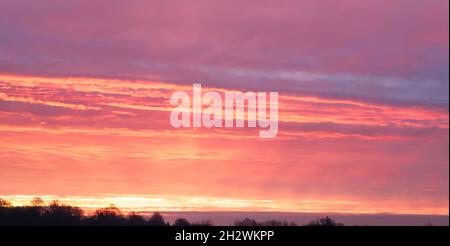 un puissant ciel multicolore avec le lever du soleil qui semble déclencher le feu sur des marais de nuages de cirrus Banque D'Images