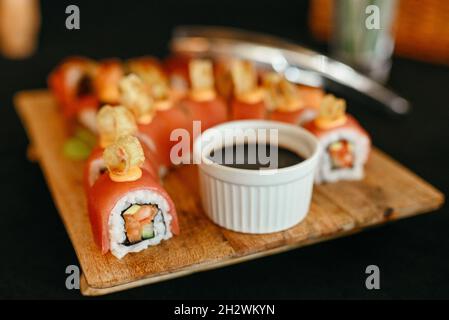 Rainbow Sushi Roll avec saumon, anguille, thon, avocat, crevettes royales, fromage à la crème Philadelphia, caviar tobica, chuka. Menu sushi. Cuisine japonaise. Banque D'Images
