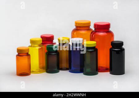 Pots de pilules en plastique transparent multicolores sur fond blanc.Isolé Banque D'Images