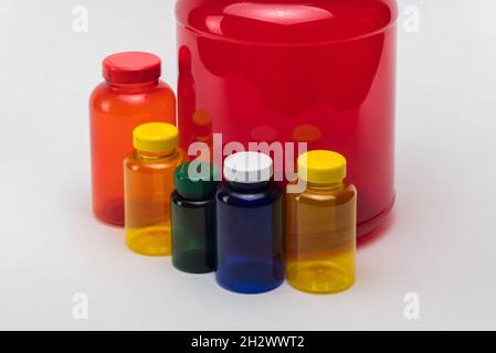 Pots de pilules en plastique transparent multicolores sur fond blanc.Isolé Banque D'Images