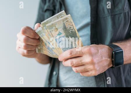 Homme détenant des billets en papier Dinar en monnaie serbe, attention sélective Banque D'Images