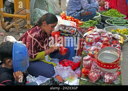 Beawar, Rajasthan, Inde, 23 octobre 2021 : une femme indienne prépare et vend des pots de terre sur un marché avant le festival hindou de Beawar.Crédit : Sumit Saraswat/Alay Live News Banque D'Images