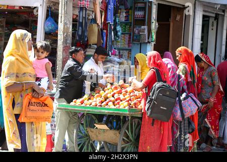 Beawar, Rajasthan, Inde, 23 octobre 2021 : un vendeur de fruits vendant des pommes à des clients sur un marché en amont du festival Diwali à Beawar.Crédit : Sumit Saraswat/Alay Live News Banque D'Images