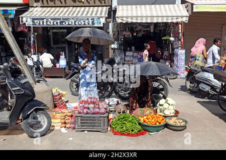 Beawar, Rajasthan, Inde, 23 octobre 2021: Les vendeurs vendant des légumes et du matériel religieux attendent des clients sur un marché avant le festival hindou de Beawar.Crédit : Sumit Saraswat/Alay Live News Banque D'Images