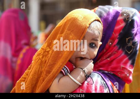 Beawar, Rajasthan, Inde, 23 octobre 2021 : une femme transportant son enfant marche sur un marché avant le festival hindou de Beawar.Crédit : Sumit Saraswat/Alay Live News Banque D'Images