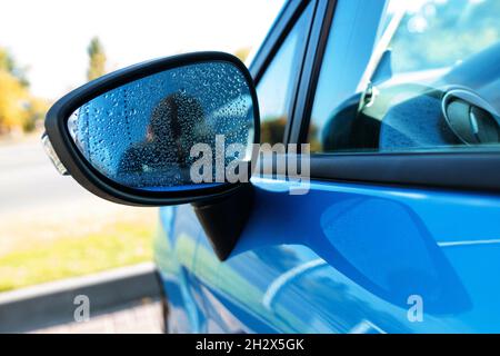 gouttes de pluie sur le miroir de vision latérale humide. temps pluvieux et lavage de voiture Banque D'Images