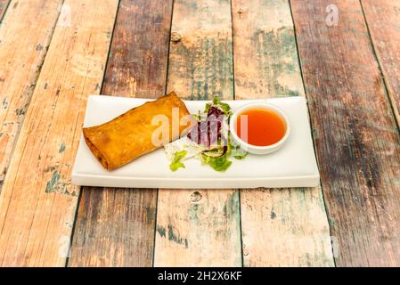 Délicieux rouleau de printemps croustillant farci de légumes et de viande hachée frite dans de l'huile d'olive avec une sauce aigre-douce pour décorer Banque D'Images