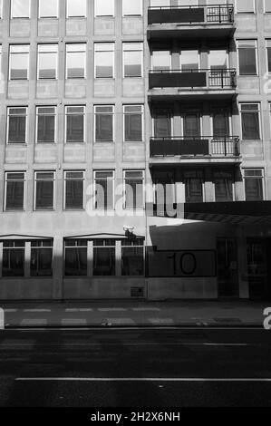 12 septembre 2021 - londres/royaume-uni : image monochrome en noir et blanc de la façade d'un immeuble de bureaux des années 1980 avec balcons sur une rue vide dans une ombre à fort contraste Banque D'Images