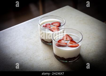 Une photo grand angle de deux verres avec yaourt et fraises Banque D'Images