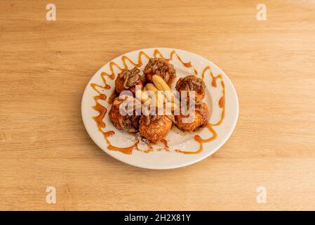 Délicieux croquettes de fromage de chèvre avec oignon caramélisé et pics de pain de campagne sur table en bois Banque D'Images