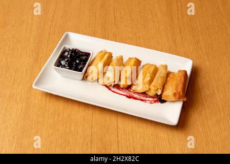 Fromage croustillant poêlé dans de l'huile d'olive avec confiture de myrtilles sur une assiette blanche Banque D'Images