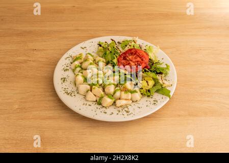 Portion de choquito grillé à la sauce verte et garniture de salade au vinaigre de modène servi dans un restaurant à tapas espagnol Banque D'Images