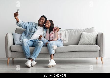 Portrait d'un couple afro-américain prenant le selfie à la maison Banque D'Images