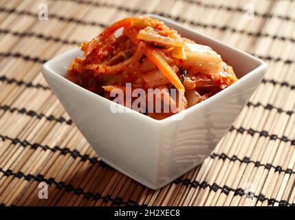 Kim chi - nourriture probiotique fermentée traditionnelle coréenne dans un bol blanc Banque D'Images