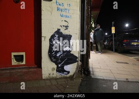 Ilfracombe, North Devogran, Royaume-Uni.24 octobre 2021.Deux graffitis sont apparus dans la nuit dans le crapaud de bord de mer d'Ilfracombe.Beaucoup spéculent que les deux pièces qui présentent Damien Hirst, qui possède la propriété dans la région ainsi que la statue de Verity de 60 pieds qui se trouve sur le port sont créées par l'aloo artiste Banksy.Une des œuvres est peinte à côté de Damien Hirsts, ancien restaurant ans, sur le mur de ce qui était autrefois l'une de ses nombreuses galeries.Crédit : Natasha Quarmby/Alay Live News Banque D'Images