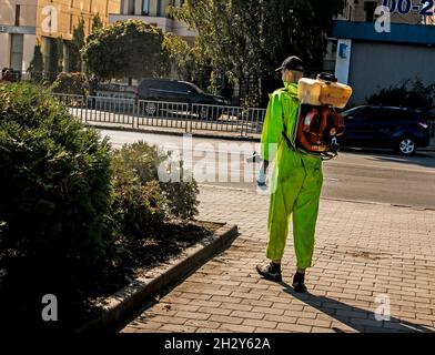 Dnepropetrovsk, Ukraine - 10.05.2021 : un employé du service municipal de la ville pulvérise des usines du paysage urbain. Banque D'Images